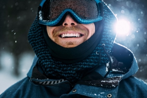 Mann mit Skibrille im Schnee